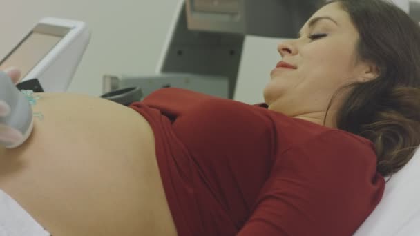 Schwangere lächelt, als sie kurz vor Ultraschall steht — Stockvideo