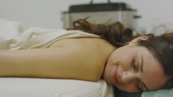 Mujer sonriendo mientras recibe un masaje en la pierna en el spa — Vídeos de Stock