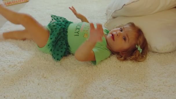 Beautiful little girl with St. Patricks Day outfit playing in rug — Stock Video