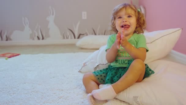 Beautiful little girl wearing St. Patricks Day outfit smiling and clapping — Stock Video