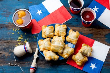 Chilean independence day concept. fiestas patrias. Chilean typical dish and drink on independence day party, 18 september. Mini empanadas, mote con huesillo, wine with toasted flour, chicha and tipical play emboque. clipart