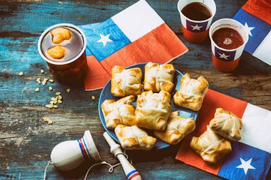 Chilean independence day concept. fiestas patrias. Chilean typical dish and drink on independence day party, 18 september. Mini empanadas, mote con huesillo, wine with toasted flour, chicha and tipical play emboque. clipart
