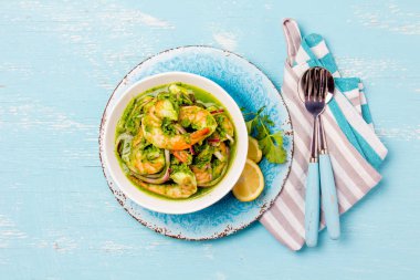 Meksika mutfağı. Aguachile de camaron. Karides aguachile. Karides eviche cebiche salatalık ile limon ve mor soğan. Üstten görünüm, mavi arka plan.