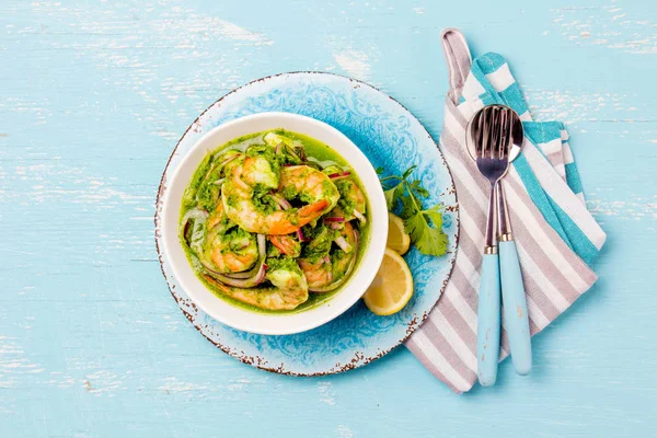Meksika mutfağı. Aguachile de camaron. Karides aguachile. Karides eviche cebiche salatalık ile limon ve mor soğan. Üstten görünüm, mavi arka plan.