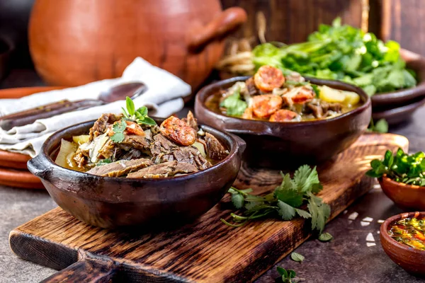 Chilean Ajiaco. Latin American food. Ajiaco - traditional chilean soup with grilled meat, onion and potato served in clay plates.