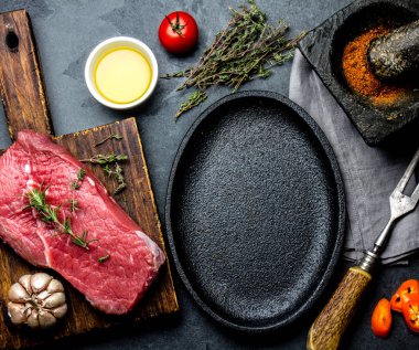 Çiğ taze et biftek Dana bonfile, otlar ve baharatlar kızartma tavası plaka çevresinde. Ackground kopya alanı ile yemek yiyecek.