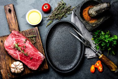 Çiğ taze et biftek Dana bonfile, otlar ve baharatlar kızartma tavası plaka çevresinde. Ackground kopya alanı ile yemek yiyecek.