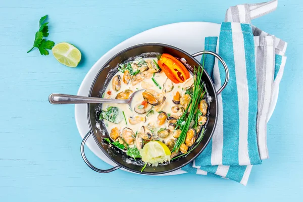 Aromatik otlar ve limon kremalı süt soslu midye. Top mavi arka plan görüntüleyin. Üstten görünüm.