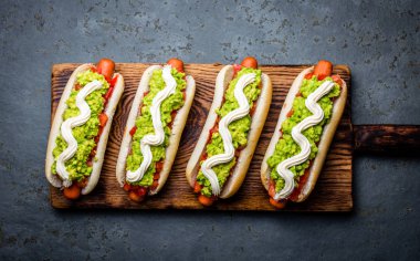 Chilean Completo Italiano. Hot dog sandwich with tomato, avocado and mayonnaise. Top view, copy space clipart