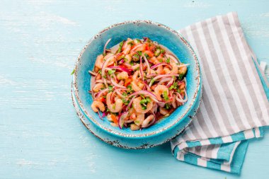Ecuadorian shrimps ceviche sebiche with tomatoes in blue bowl, wooden blue background. Traditional ecuadorian colombian or mexican dish clipart