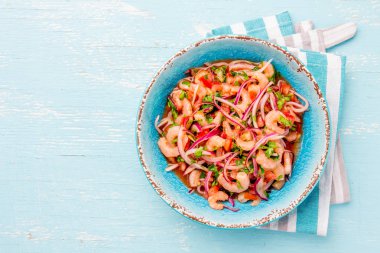 Ecuadorian shrimps ceviche sebiche with tomatoes in blue bowl, wooden blue background. Traditional ecuadorian colombian or mexican dish clipart