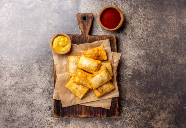Kızarmış peynirli empanadas. Geleneksel Latin Amerika Aperatif ahşap tahta chili sos ve hardal ile servis. Üstten görünüm, taş arka plan.