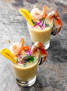 Perulu seviche Leche De Tigre. Çiğ balık kokteyl ceviche kireç, kıyma, biber ve Salantro ile. Geleneksel Perulu Gıda dekore edilmiş yengeçler, srimps ve muz fiş.