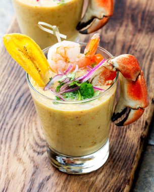 Perulu seviche Leche De Tigre. Çiğ balık kokteyl ceviche kireç, kıyma, biber ve Salantro ile. Geleneksel Perulu Gıda dekore edilmiş yengeçler, srimps ve muz fiş.