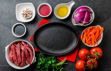 Perulu çanak Lomo saltado - bonfile biftek, sarı biber, domates, soğan, yağ, soya sosu, sirke, garlik siyah plaka etrafında yemek için Ingredientes
