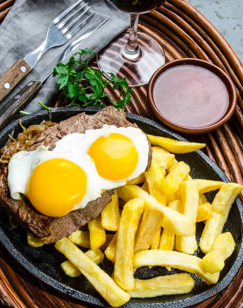 Peruvian Latin American food. Lomo a lo pobre. Beef tenderloin whit fried potatoes french fried and egg served with chile sauce and wine
