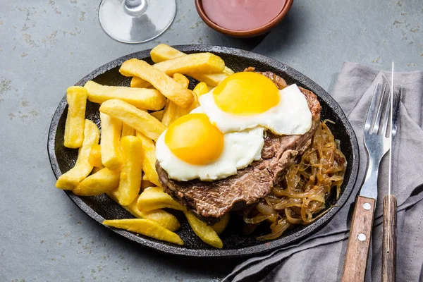 Peruvian Latin American food. Lomo a lo pobre. Beef tenderloin whit fried potatoes french fried and egg served with chile sauce and wine