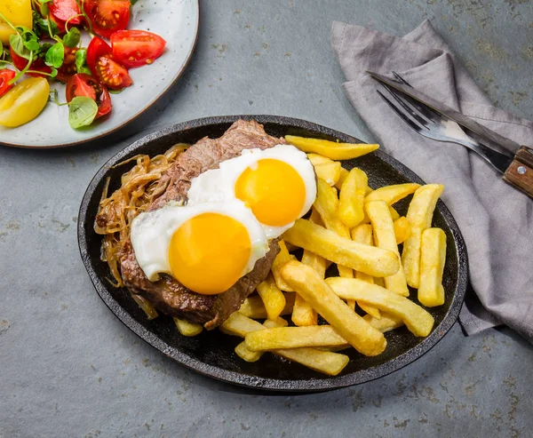 Peruvian Latin American food. Lomo a lo pobre. Beef tenderloin whit fried potatoes french fried and egg served with chile sauce and wine