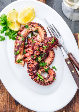 Izgara ahtapot üzerinde beyaz şarap, üstten görünüm ile beyaz plaka serverd. Deniz ürünleri.