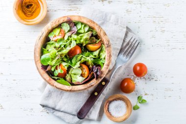Vejetaryen salatası marul ve domates wihte zemin üzerine zeytin ahşap kase