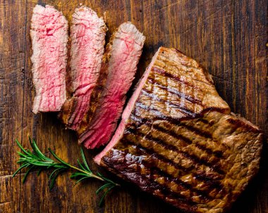 Ahşap tahta Barbekü, Barbekü et Dana bonfile hizmet ızgara Orta nadir sığır eti biftek dilimlenmiş. Üstten görünüm, arduvaz arka plan.