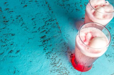 Şili geleneksel alkollü içki Terrremoto. Ananaslı dondurmayla, nar suyu, pisco ve beyaz şarap likör. Mavi arka plan.