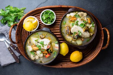 Deniz ürünleri balık çorbası kil kase kişniş ve limon ile servis. Üstten görünüm, kopya alanı.