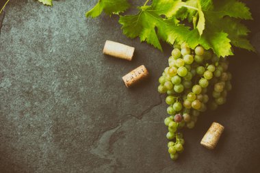 Şarap üzüm ve tirbuşon kavramı, taş arka plan, üstten görünüm.