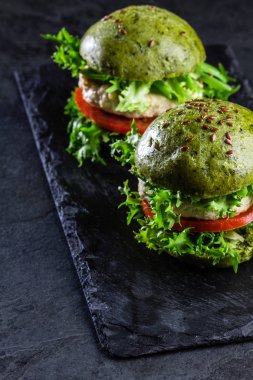 Yeşil ıspanak ekmeği ve tavuk burgerler. Arduvaz arka plan