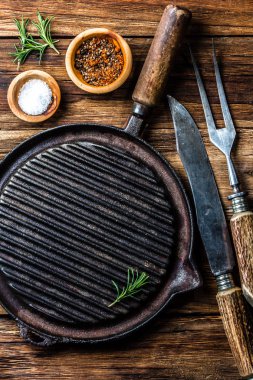 Arka plan kavramı yemek. Vintagr demir ızgara tava, çatal bıçak takımı ve baharat. Üstten görünüm