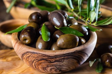 Zeytin ve zeytin yağı zeytin ahşap kase zeytin ahşap kesme tahtası üzerinde ahşap rustik zemin üzerine zeytin ağacı dalı