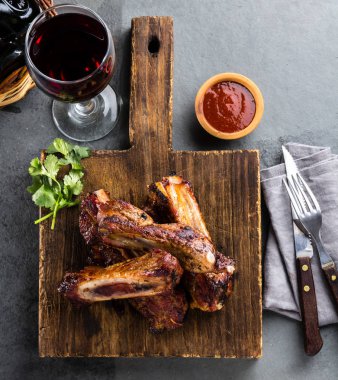 Biber sosu ve şarap arduvaz arka plan ile kesme tahtası üzerinde domuz kaburga. üstten görünüm