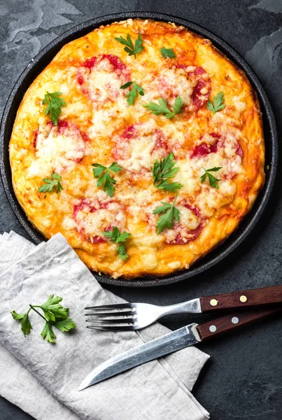 Homemade pizza with salami on slate background