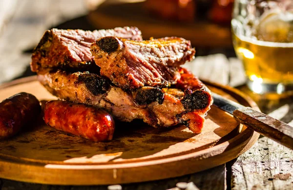 Barbekü domuz kaburga ve sosis ile bira ahşap tahta üzerinde