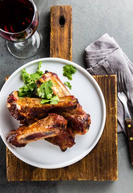 Barbekü domuz kaburga ile şarap, üstten görünüm, arduvaz arka plan beyaz tabakta servis