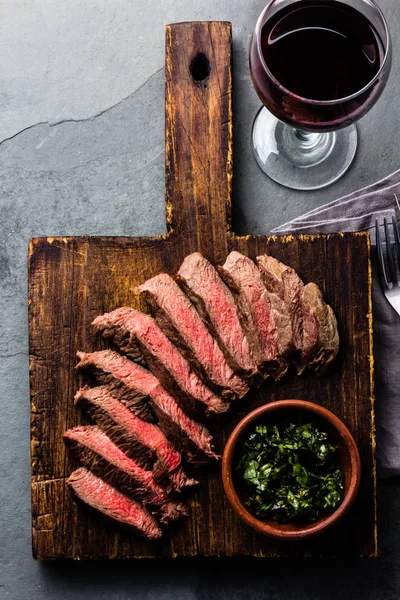 在木板上的牛肉中稀有牛排片 石板背景的红酒杯 — 图库照片
