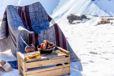 Winter picnic in chilean argentine snow mountaines Andes with hot meat food and drink yerba mate. clipart