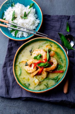 Tay Karides Curry yeşil. Tayland geleneği yeşil köri karides karides ve Hindistan cevizi sütü çorbası. Mavi Plaka gri arka plan üzerinde yeşil köri.