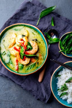 Tay Karides Curry yeşil. Tayland geleneği yeşil köri karides karides ve Hindistan cevizi sütü çorbası. Mavi Plaka gri arka plan üzerinde yeşil köri.