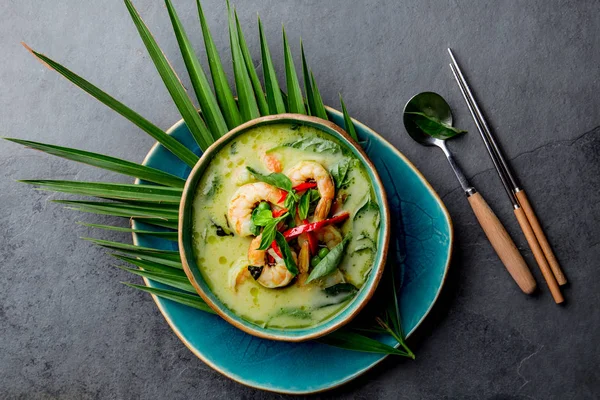 THAI SHRIMPS VERDE CURRY. Tailandia tradición sopa de curry verde con camarones camarones y leche de coco. Curry verde en placa azul sobre fondo gris . — Foto de Stock