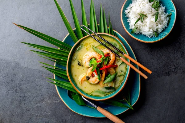 THAI SHRIMPS GREEN CURRY. Soupe au curry vert traditionnelle de Thaïlande avec crevettes et lait de coco. Curry vert en plaque bleue sur fond gris . — Photo