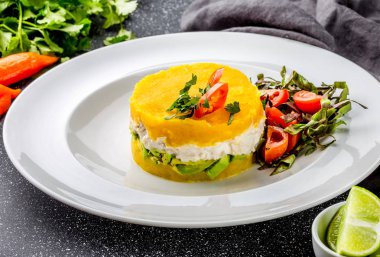 Perulu Gıda. Causa rellena de pollo. Tavuk causa rellena. Sarı patates, tavuk, avokado beyaz plaka üzerinde geleneksel Perulu çanak