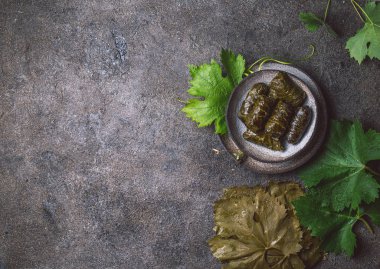 Geleneksel Orta Doğu dolma veya tolma. Üzüm et ve pilav ile doldurulmuş bırakır. Gri plaka, gri beton zemin üzerine