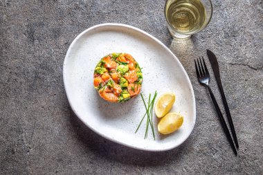 Perulu gıda. Avokado, soğan ve limon beyaz tabakta somon meze beyaz şarap ile hizmet