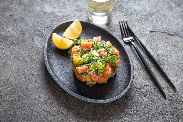 Nourriture péruvienne NIKKEI. Ceviche d'avocat de saumon sur plaque noire, vue de dessus de fond noir — Photo