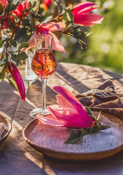 Посадка стола в саду при солнечном свете. Стол украшен цветами магнолии под деревом Магнолия . — стоковое фото