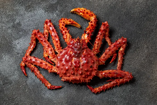 Red king crab on gray background. King crab, lemon and cilantro, top view