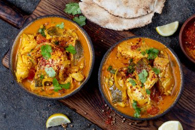Hint Yemekleri. Naan ekmek, gri plaka, siyah arka plan ile Geleneksel Kerala Balık Curry 