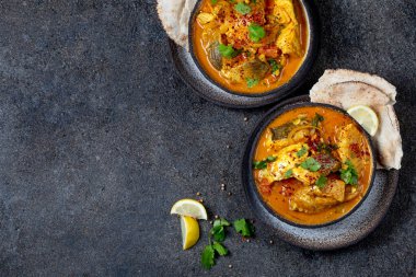 Hint Yemekleri. Naan ekmek, gri plaka, siyah arka plan ile Geleneksel Kerala Balık Curry 