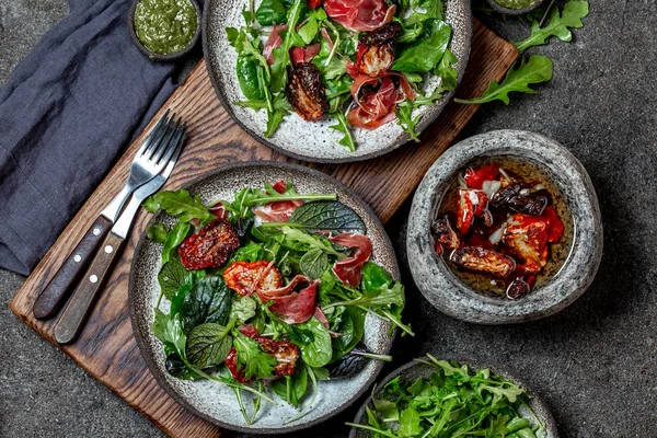 Salad with arugula, spinach, dried tomato and ham serrano paleta iberica. Low carbs keto recipe — Stock Photo, Image